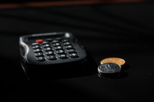 Black calculator and a couple of coins